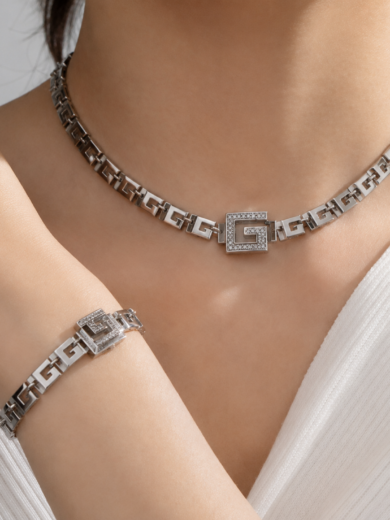 Découvrez la Parure Impériale Argentée™. Un ensemble complet comprenant collier, bracelets, bague et boucles d'oreilles au design luxueux inspiré de l'architecture grecque moderne.