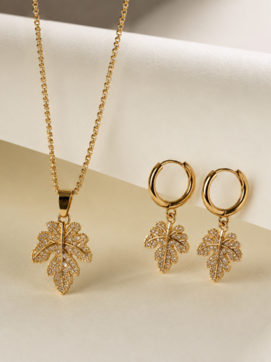 Parure feuille en or plaqué avec collier et boucles d'oreilles assortis. Cristaux scintillants, élégance naturelle et garantie à vie.