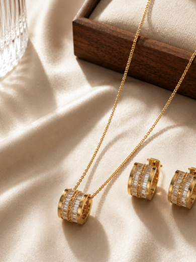 Parure Lumière Royale dorée avec collier fin et boucles d'oreilles sertis de cristaux scintillants sur fond élégant beige.
